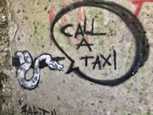 Ein Graffiti das eine Schlange abbildet, die "Call a Taxi" in einer Sprechblase sagt.